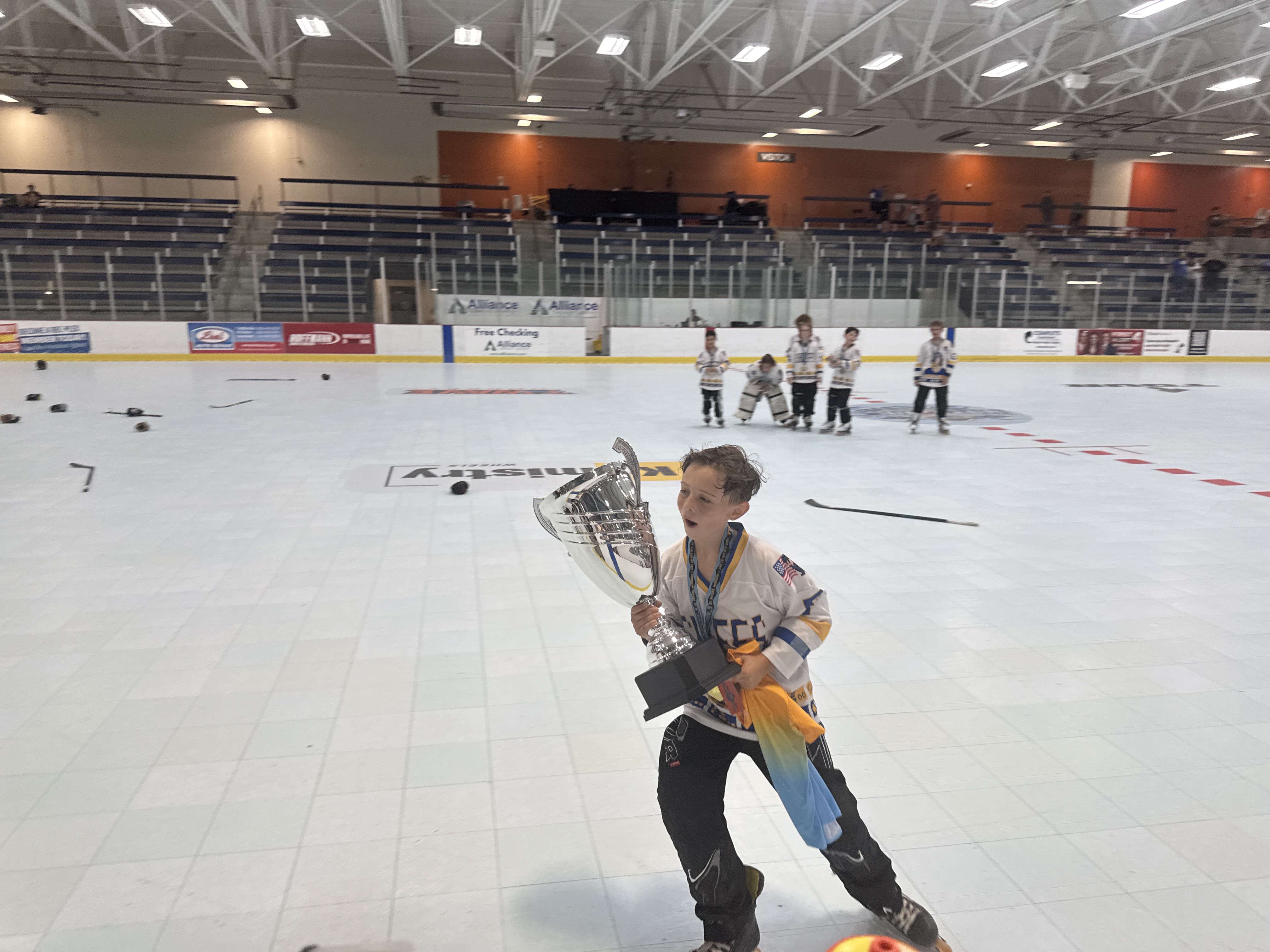 Young player skating with the championship trophy